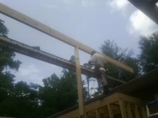 Carpenter setting a ridge beam over a new addition frame — Ice Dam Removal by Roofing Brothers in Shoup