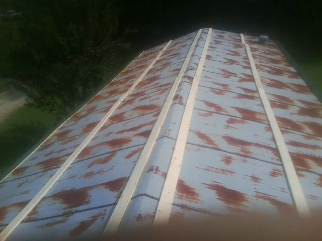 Rusted metal roof panels with new wood purlins before replacement — Storm Damage Roof Repair in Shoup by Roofing Brothers