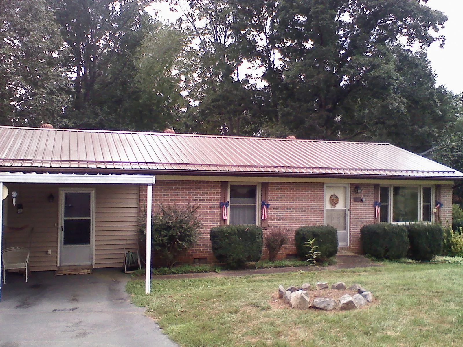 Bronze metal roof and carport on a brick ranch home — Roof Repair work by our crew in Shoup